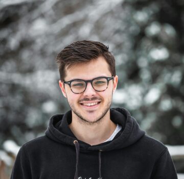man in black hoodie wearing black framed eyeglasses